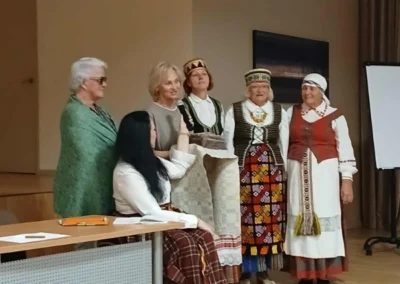 Moterų pasirodymas su tautiniais drabužiais asociacijos renginio metu